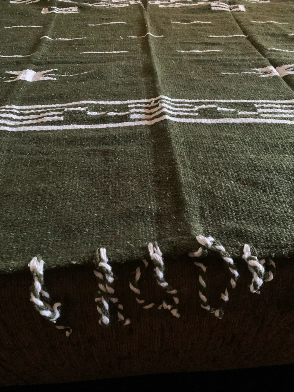 olive green Mexican-style blanket poncho featuring a geometric pattern